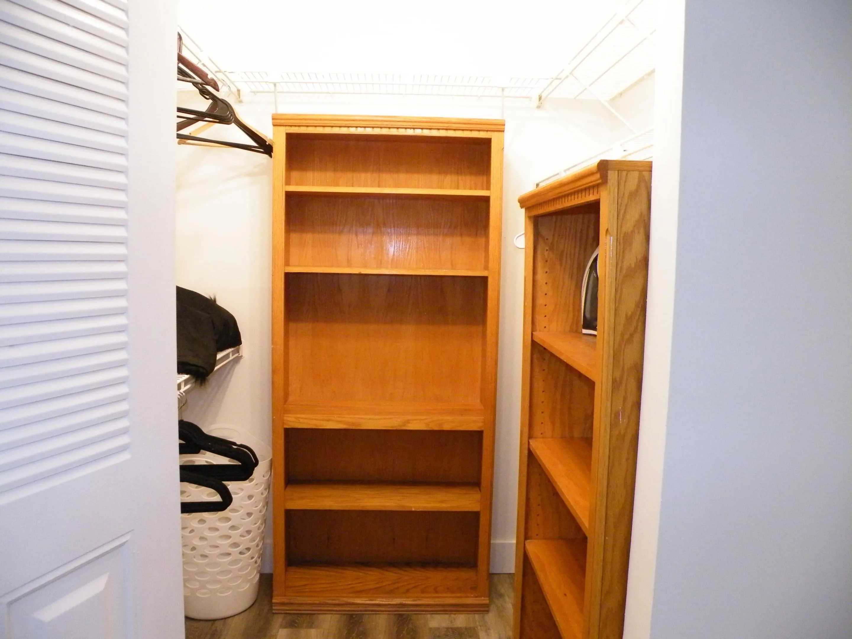 Built-in shelving units with adjustable shelves and a wire rack storage system