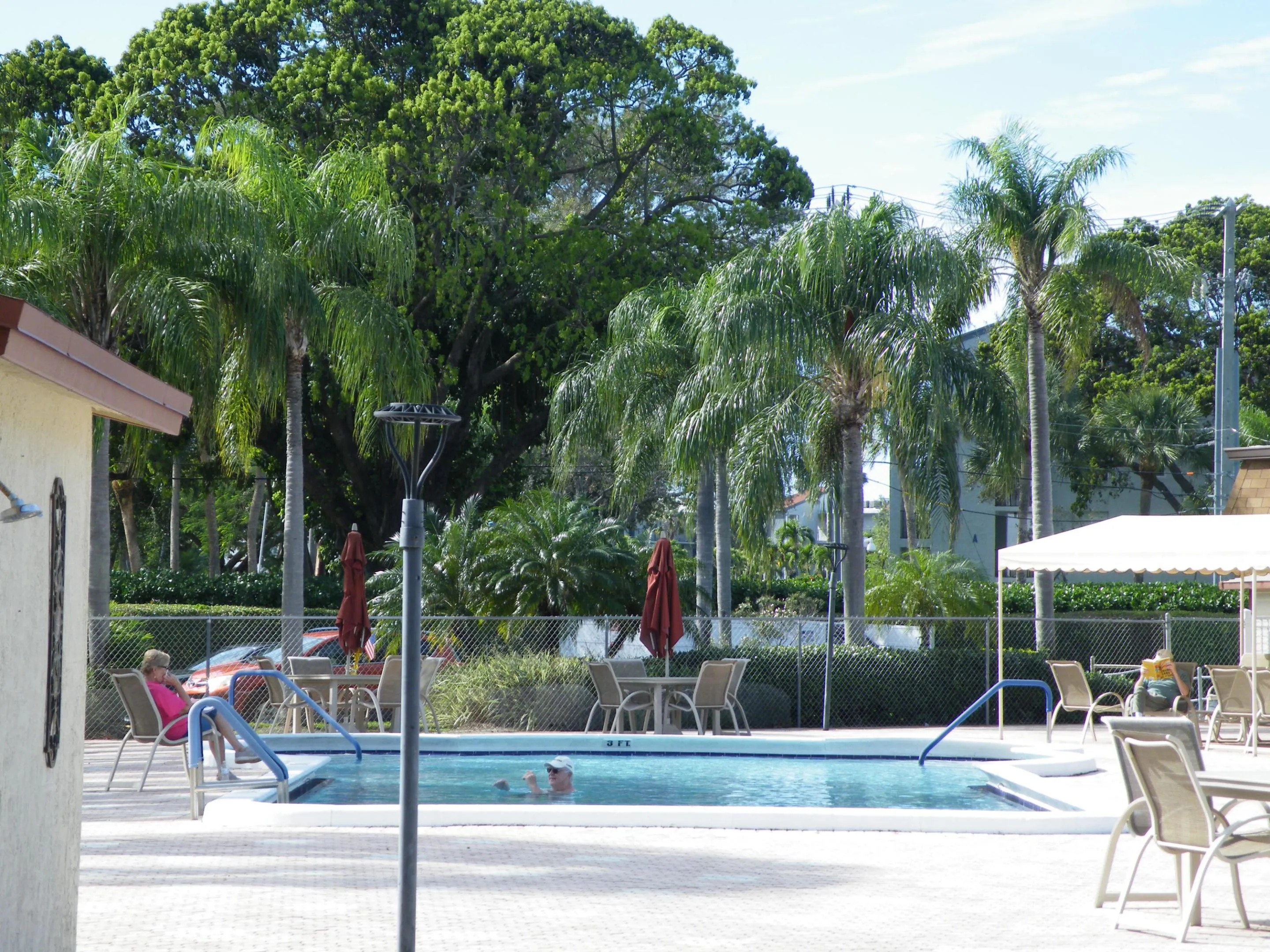Community pool with an integrated spa, surrounded by a paved deck