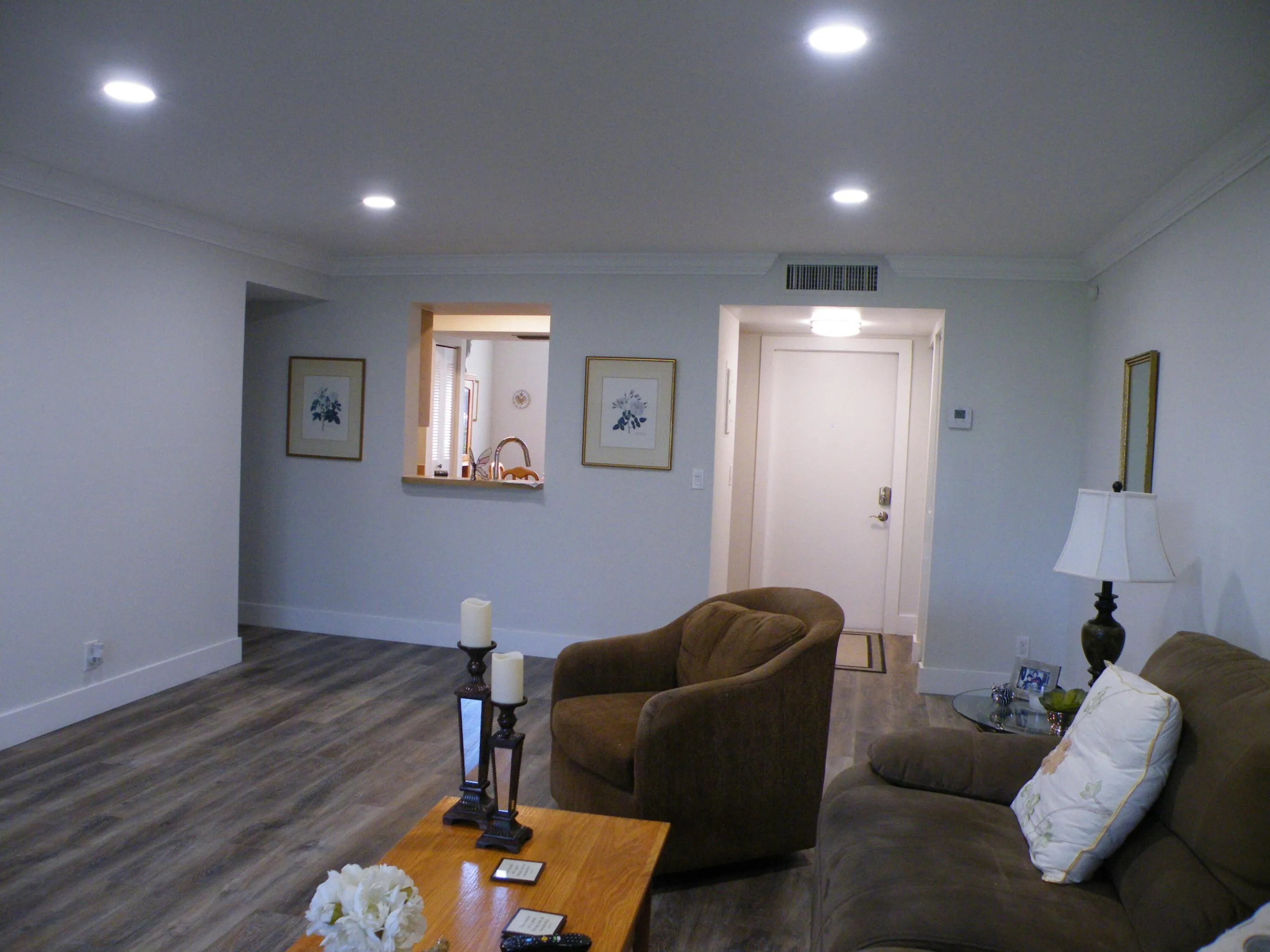 Recessed ceiling lighting, wood-finish flooring, crown molding, pass-through window, and white interior doors