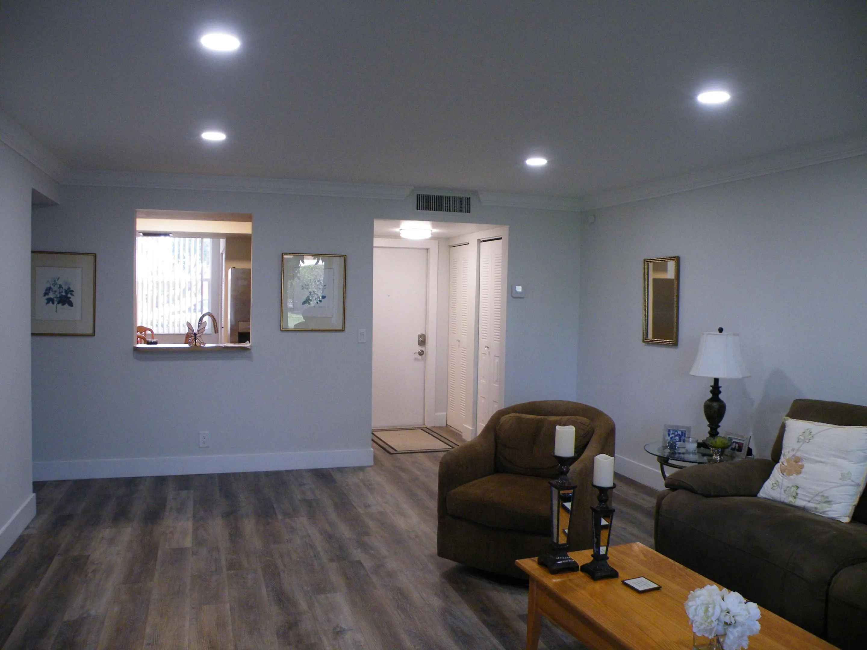 Recessed lighting, crown molding, wood-finish flooring, and a kitchen pass-through window