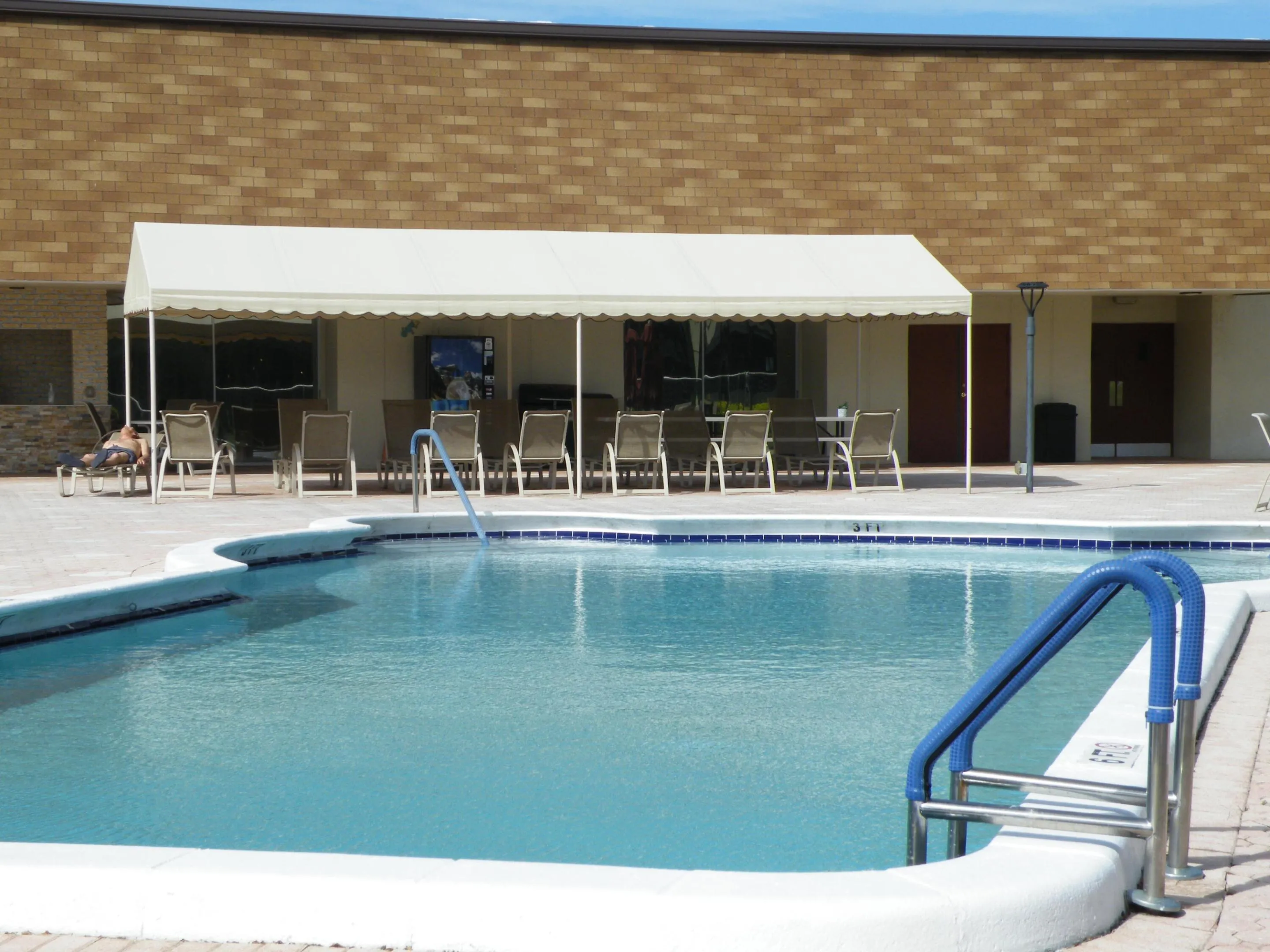 Swimming pool with blue tile accents and metal handrails