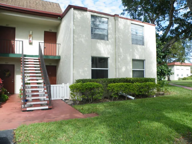 Two-story stucco exterior with brown trim and a shingle roof