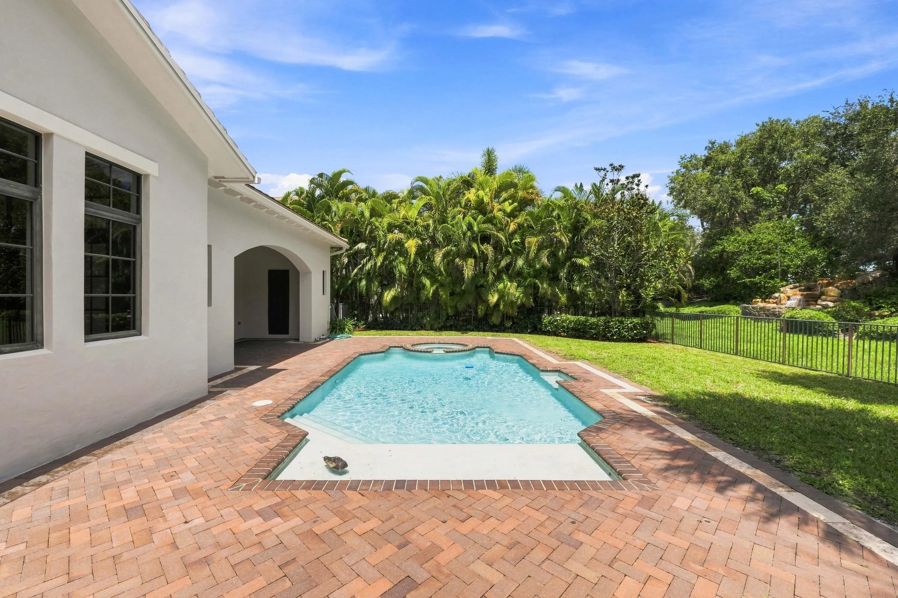 Pool and patio surrounded by landscaping