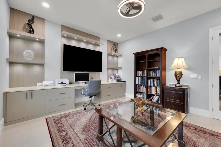 Built-in workstation with integrated cabinetry, recessed lighting, and wall-mounted shelving
