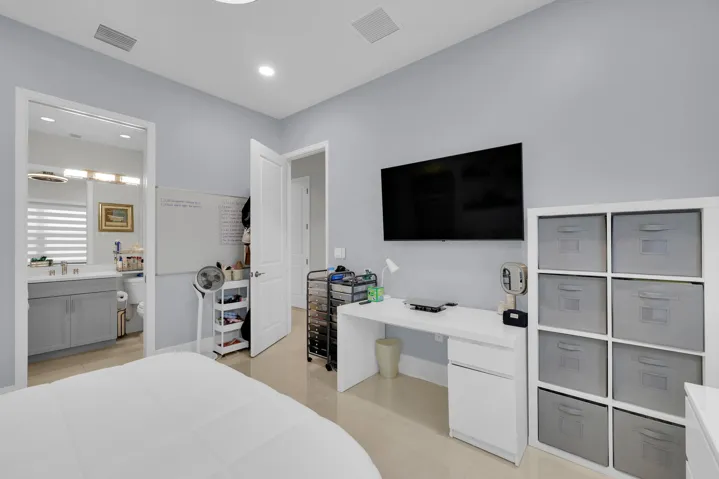 Light-toned flooring, contemporary recessed lighting, and a white vanity with gray cabinetry