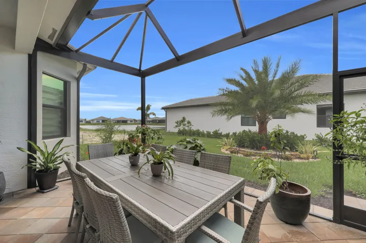 Screened lanai featuring a patio with multi-toned pavers and a clear structural enclosure