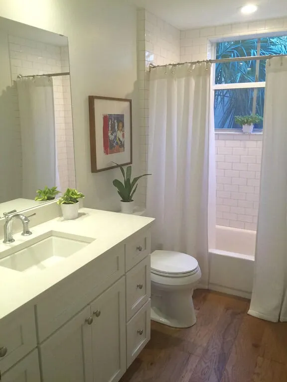 White shaker-style vanity with integrated sink and chrome faucet