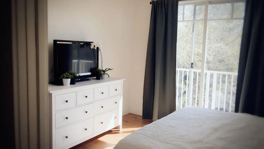 Hardwood-style flooring, white walls, and a glass-paned door with a balcony