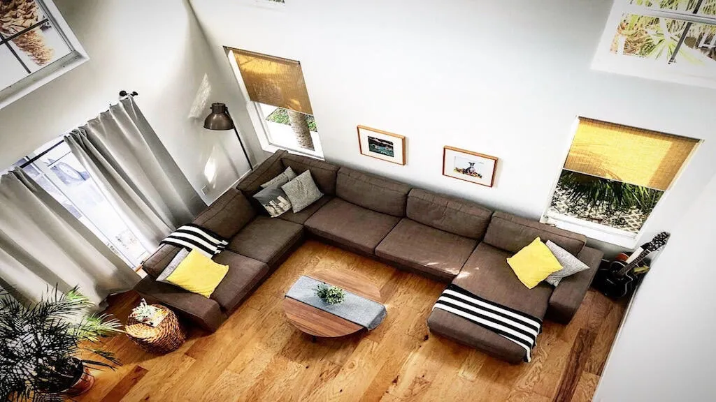 High ceilings, wood-finish flooring, multiple windows, built-in recessed lighting, and a modern floor lamp