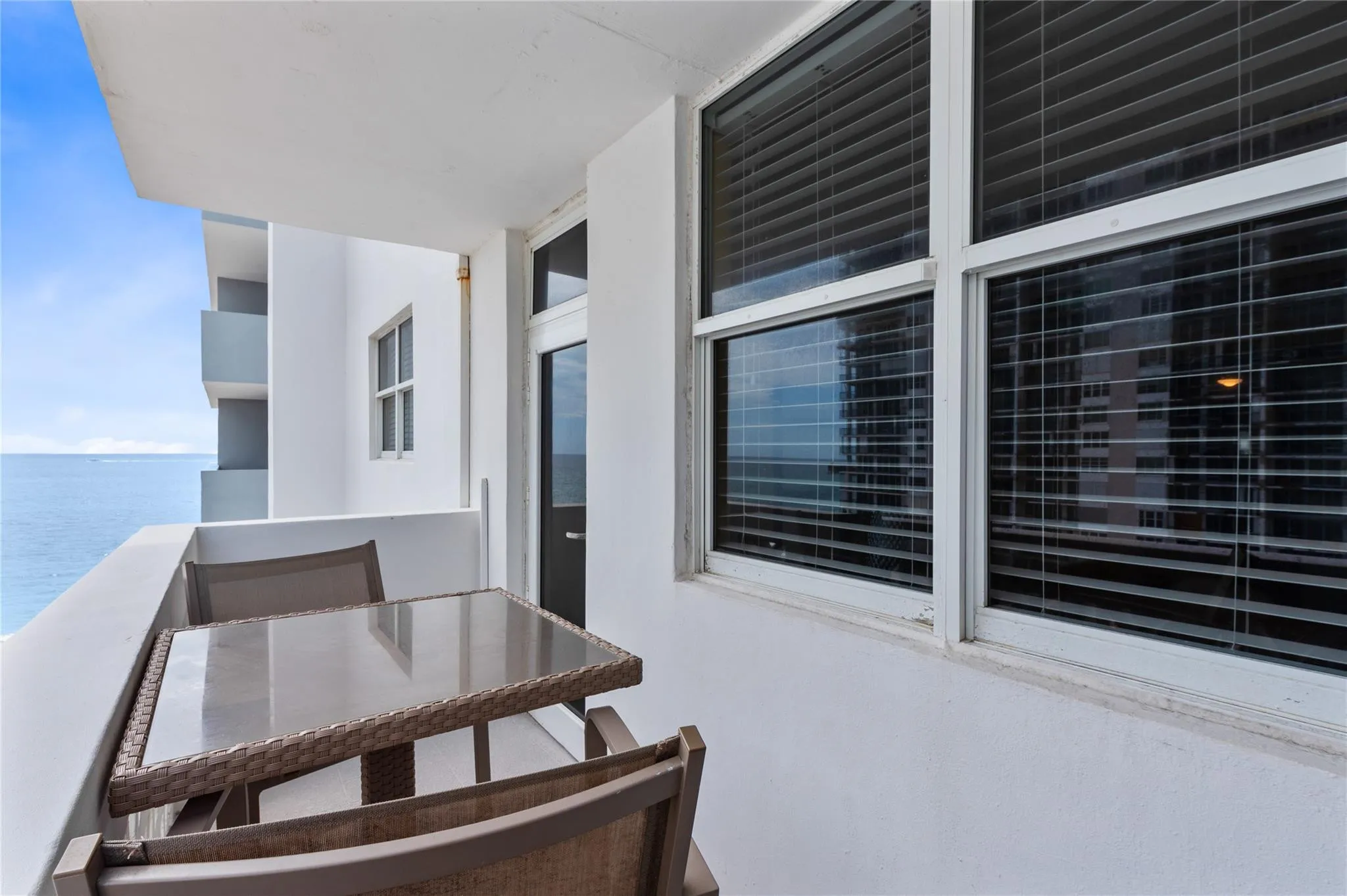 Private outdoor balcony featuring a painted concrete railing and a scenic water backdrop