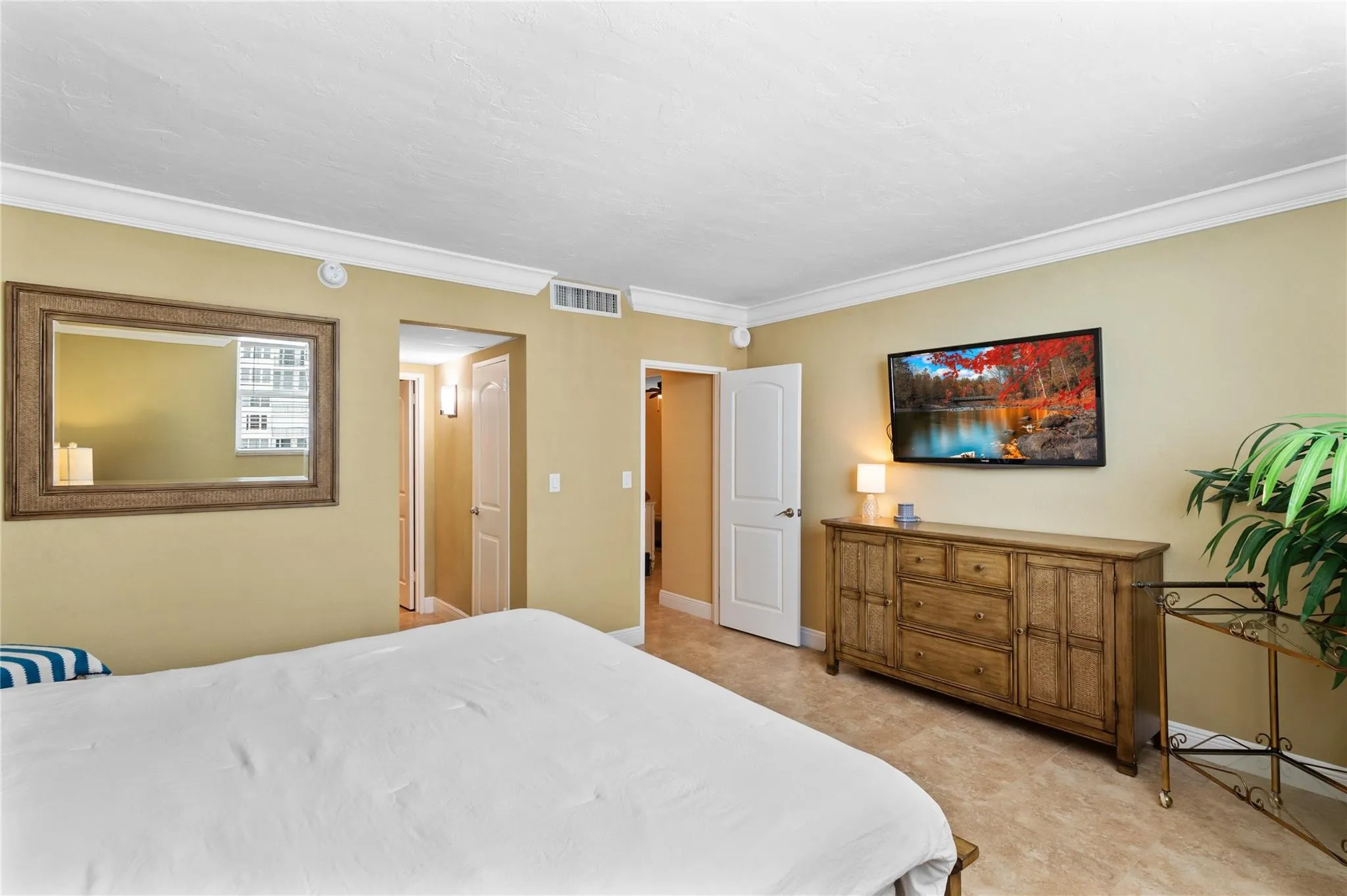 Crown molding accents the ceiling, complemented by light-toned wall paint and tile flooring