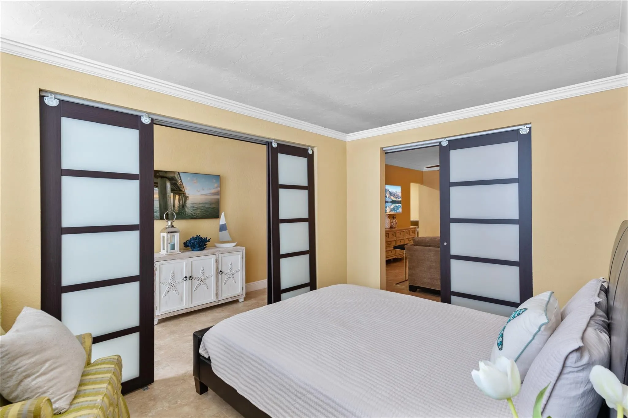 Smooth-gliding barn doors with frosted glass panels, crown molding, and tiled flooring