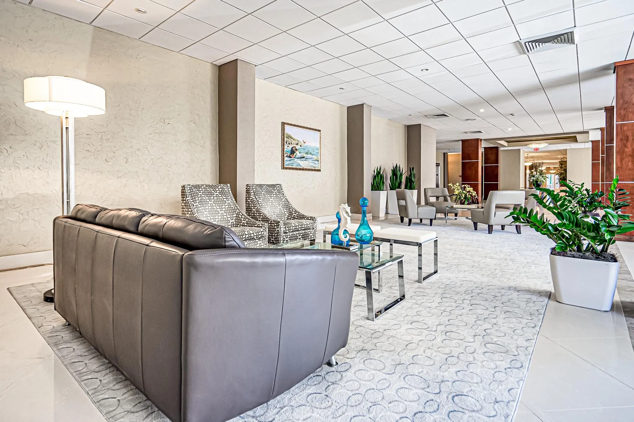 Spacious common area featuring textured walls, neutral color palette, recessed lighting, and tile flooring