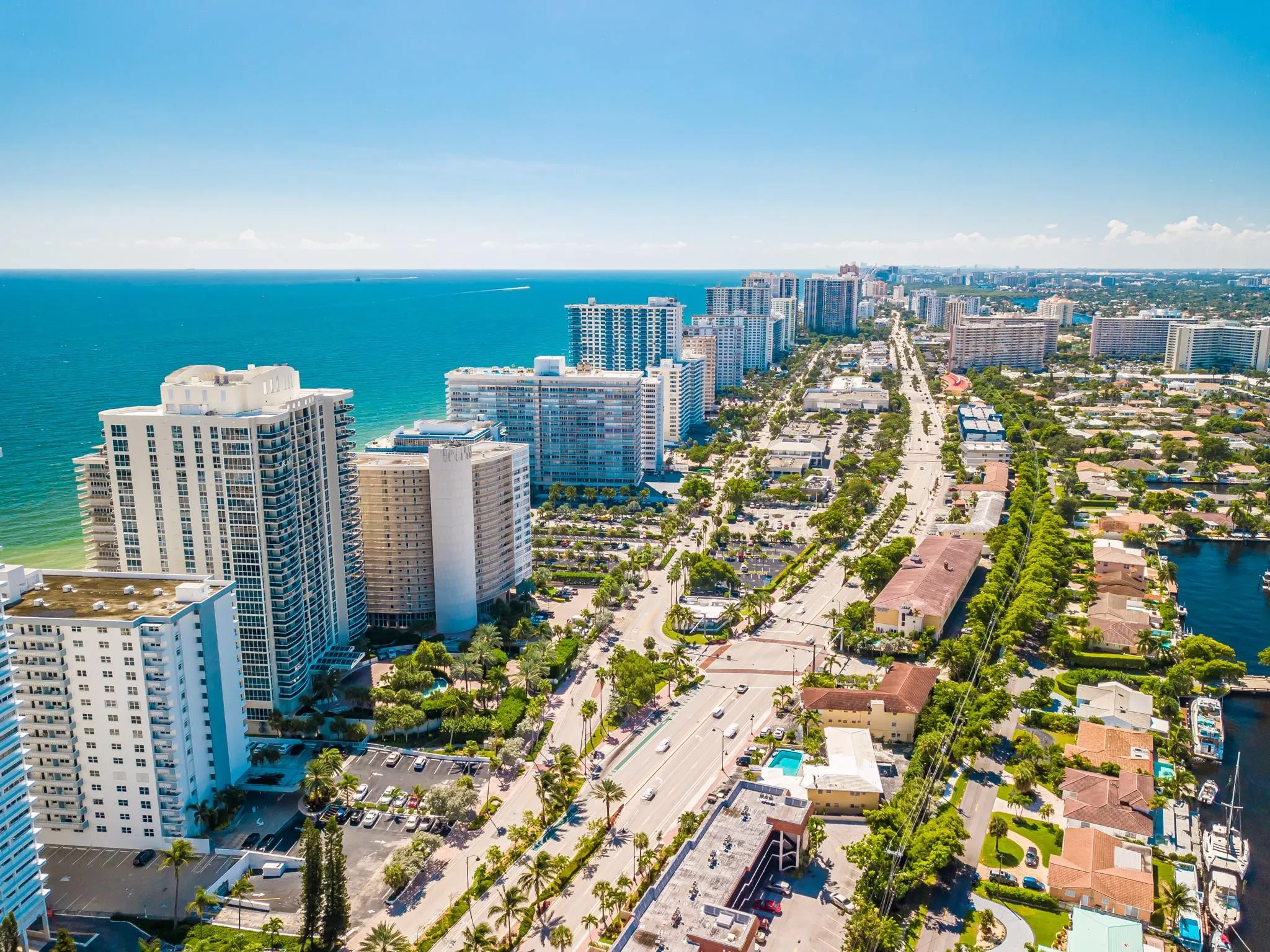 Coastal city setting with high-rise buildings, extensive waterway, and lush landscaping