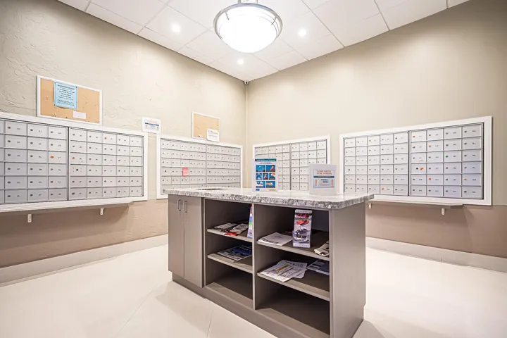 Mailroom featuring individual mailboxes, a central island with storage, and recessed lighting