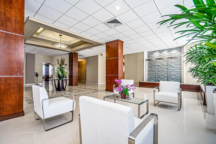 Polished tile flooring, wood-paneled columns, recessed lighting, and a decorative chandelier create a sophisticated ambiance