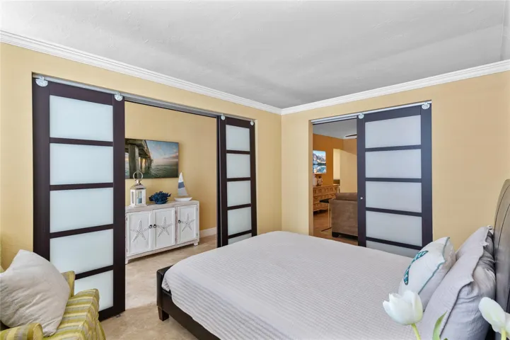 Smooth-gliding barn doors with frosted glass panels, crown molding, and tiled flooring