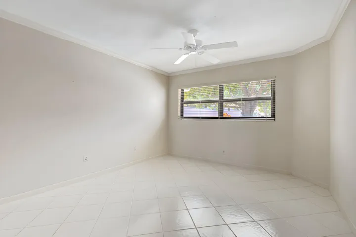 Another view of the flexible ground-floor room highlights its generous space and double French doors, offering an ideal setting for a guest bedroom, den, or home office.