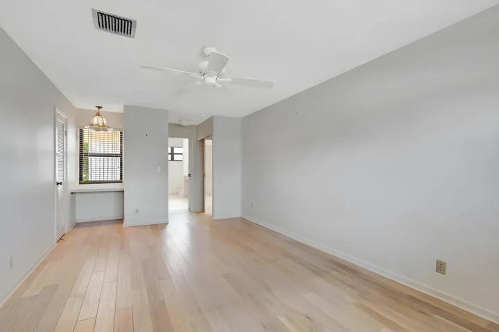 Generous second-floor primary suite with double-door entry, light wood-finish flooring, private ensuite bath, and additional space ideal for a home office or sitting area.