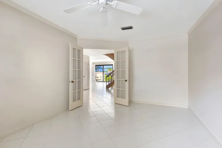 Flexible ground-floor space with double French doors, ideal as a bedroom, den, or home office, with an adjacent full bath.