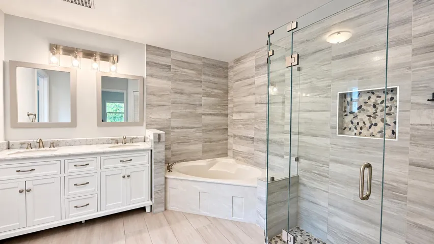 Double vanity with white cabinetry and stone countertops