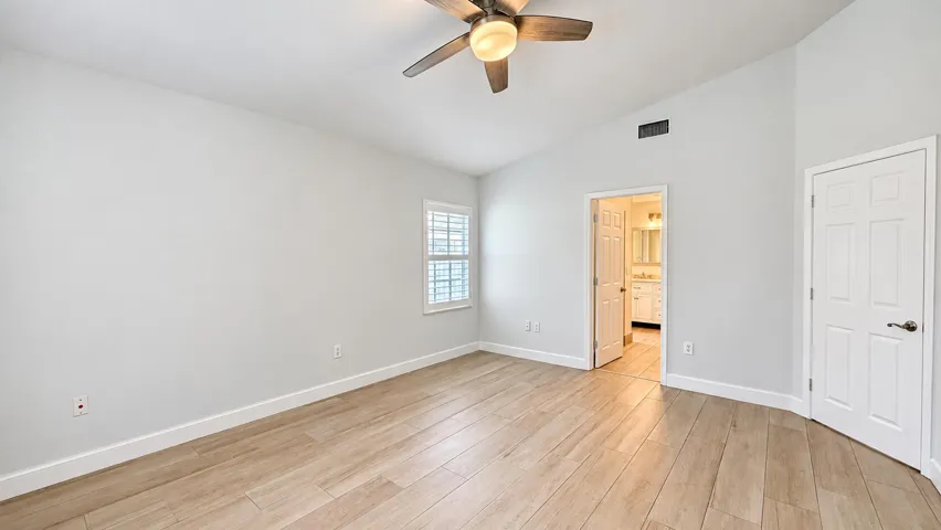 Wood-finish flooring, plantation shutters, and a ceiling fan