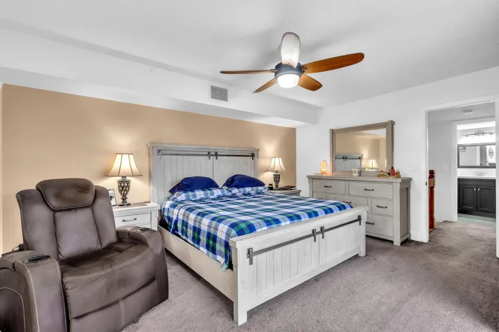 PRIMARY BEDROOM WITH SLIDING DOORS TO BALCONY OVERLOOKING HUGE LAKE .