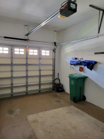 Tall ceilings in the garage means you can add additional tall cabinetry to make use of all the space. Note garage door opener.