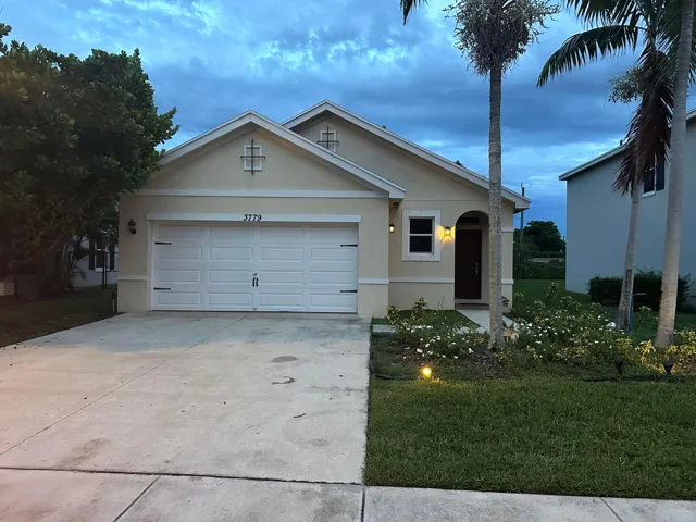 Stucco exterior with an arched entryway, attached garage, and a concrete driveway