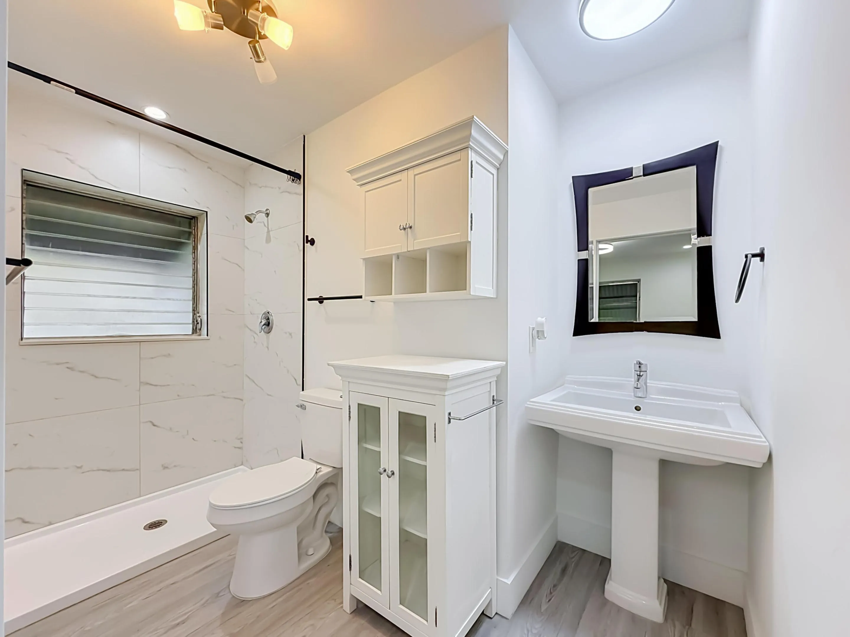 Shower with marble-look tile surround and black-finish hardware