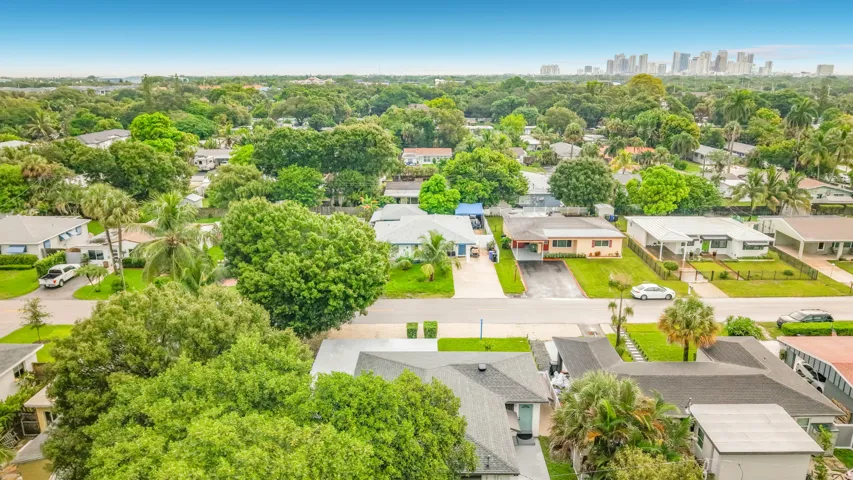 Expansive residential neighborhood with mature trees, established properties, and a distant cityscape