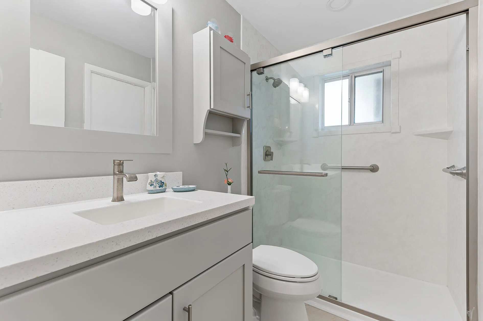 Updated guest bathroom with glass enclosed shower.