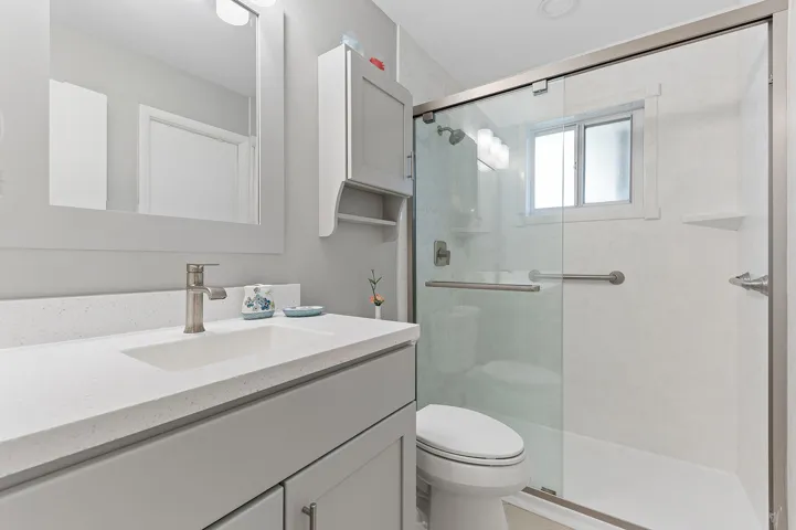 Updated guest bathroom with glass enclosed shower.