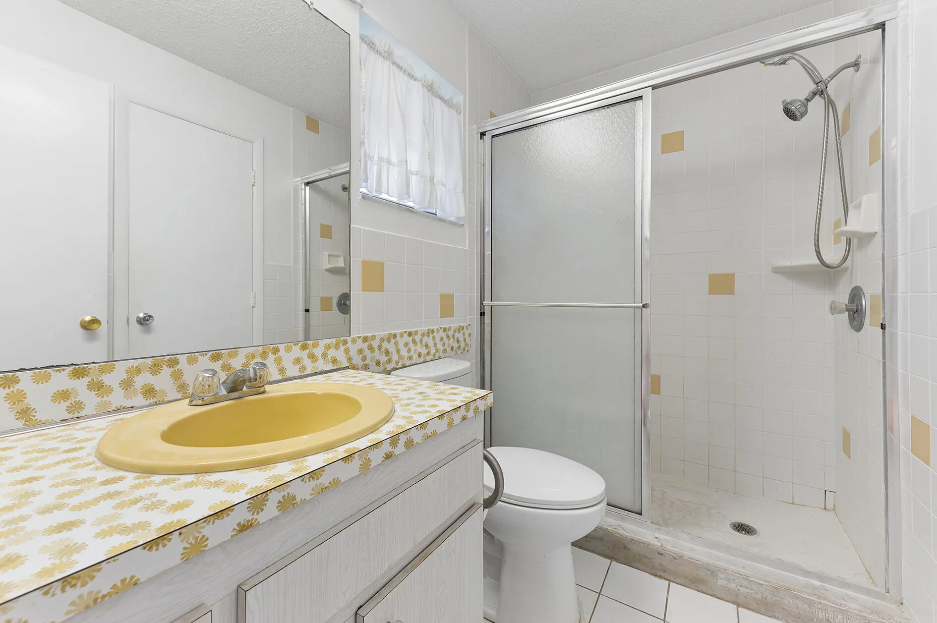 Guest bathroom with glass enclosed shower. Access from both family room and guest bedroom.
