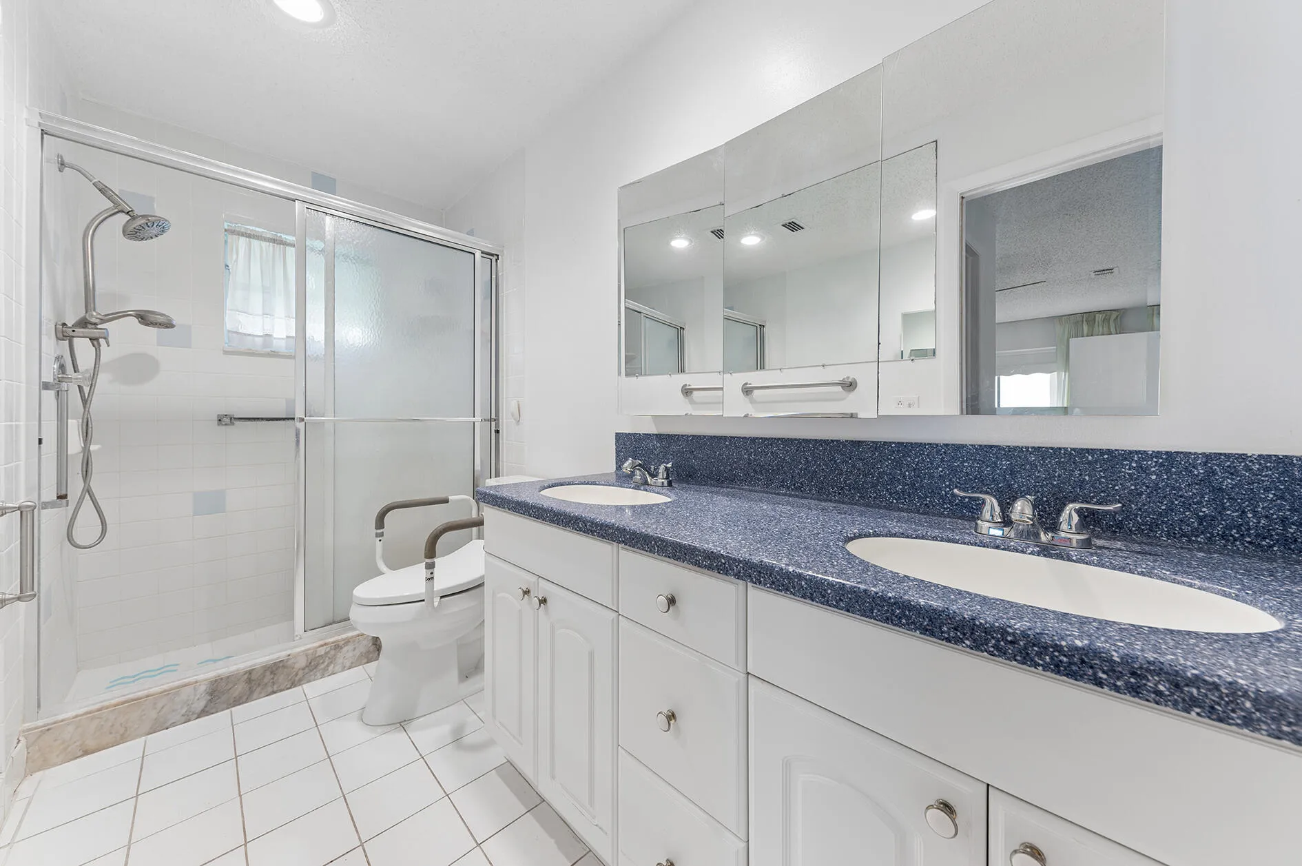 Master Bathroom with glass enclosed shower. Oversized vanity with double sink. All tiled.