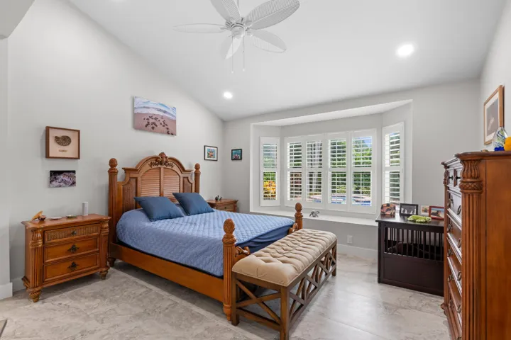 Spacious primary suite with windows overlooking pool, spa and backyard