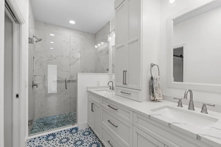Completely remodeled primary bath w/walk in shower, custom dual vanities and beautiful tile work