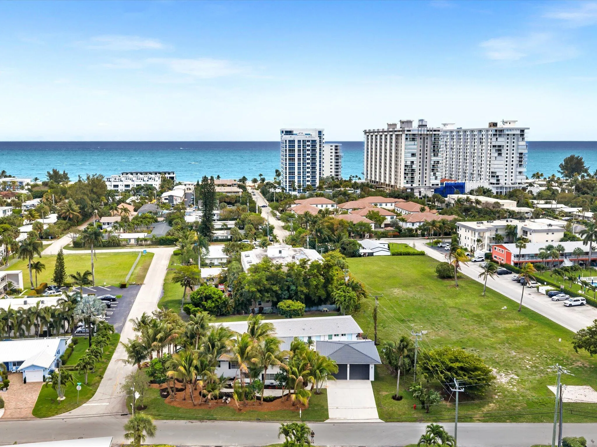 Coastal neighborhood with established landscaping and clear blue ocean beyond