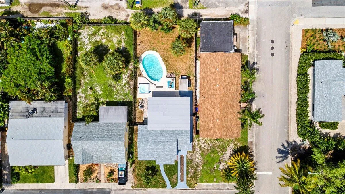Property featuring an in-ground swimming pool, adjacent spa, and mature landscaping