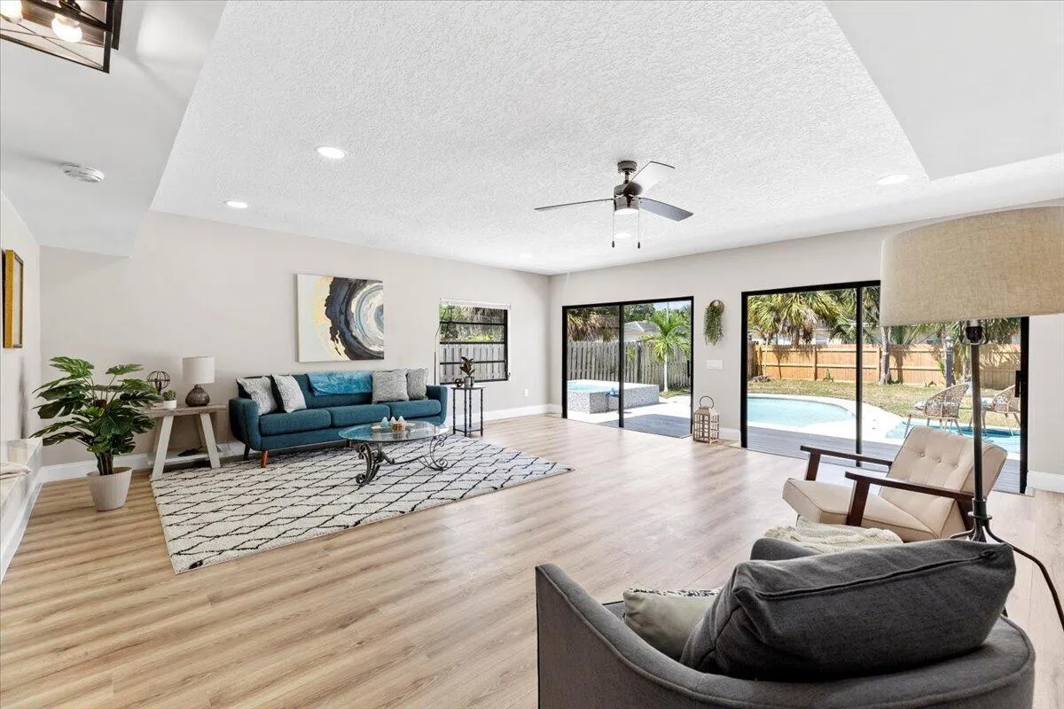 Spacious living area featuring wood-finish flooring, recessed lighting, and a ceiling fan