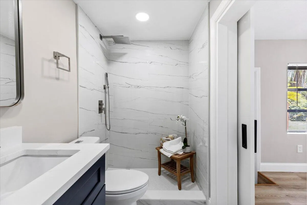 Bathroom featuring a vanity with a white countertop, a built-in sink, and a dark blue cabinet