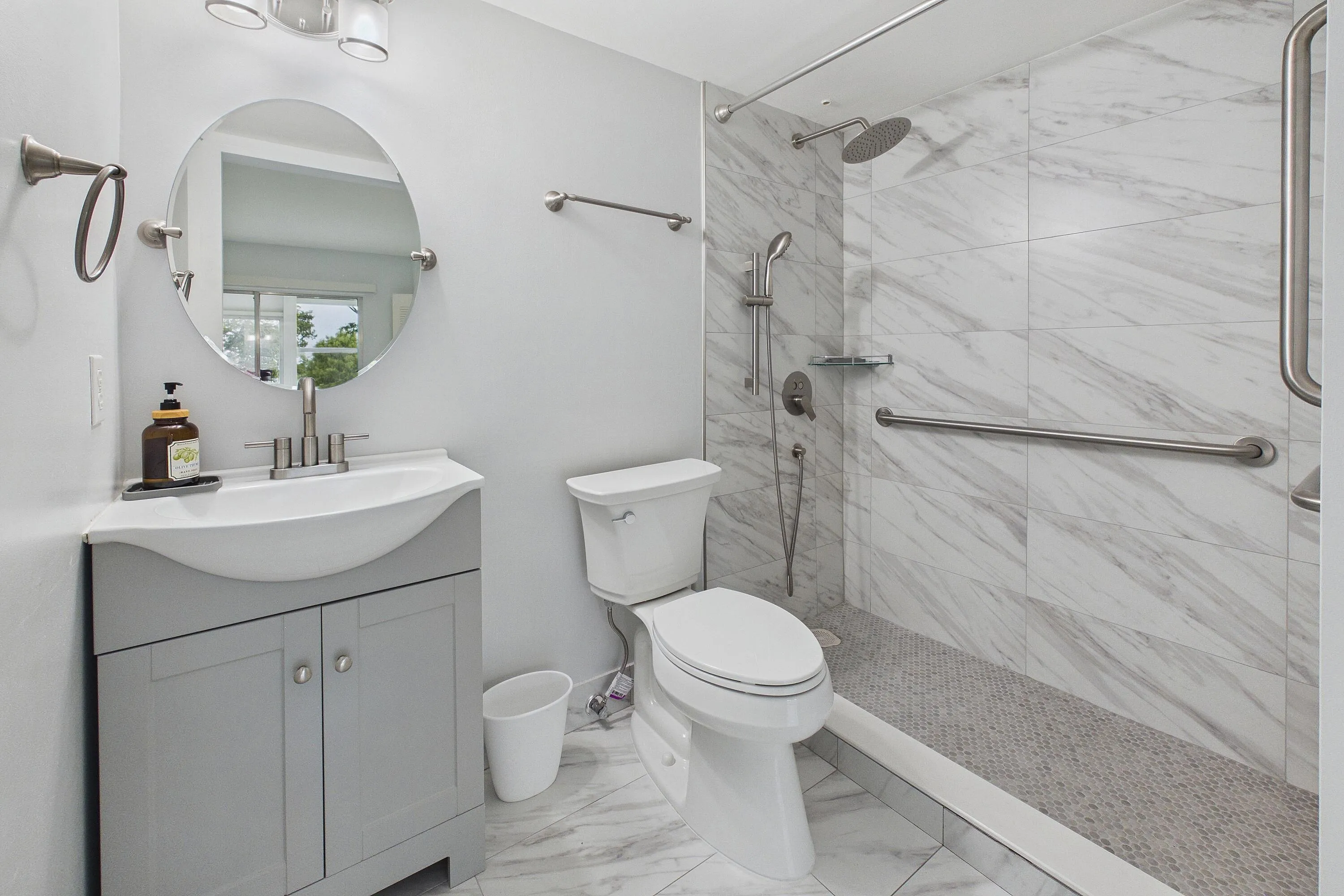 Renovated handicap accessible walk-in shower, vanity with integrated sink and cabinet storage