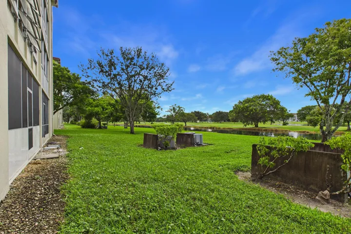 Expansive green space featuring mature trees and a tranquil water feature