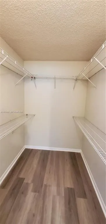 Huge Walk In Closet in Master Bedroom with Beautiful Flooring and Shelving