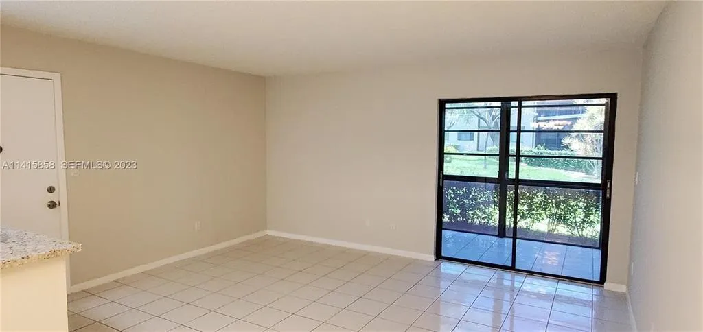 Vie of Liing Room Area and Sliding Glass Doors to Glass Enclosed Patio