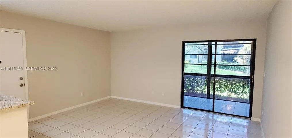 Vie of Liing Room Area and Sliding Glass Doors to Glass Enclosed Patio
