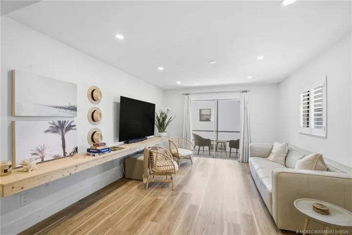 The long, open living area offers flexible seating and entertaining options with a clean coastal aesthetic and seamless access to the outdoors.