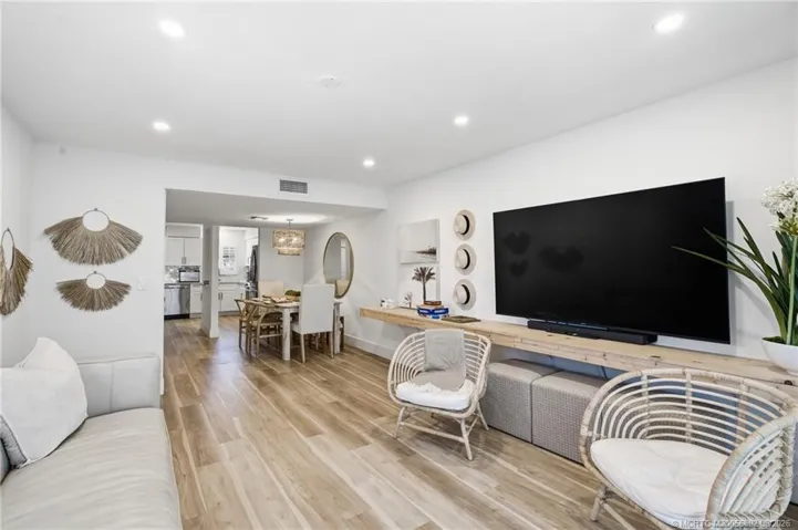 Reverse view of the spacious living area highlights the open flow into the dining room and kitchen, creating a connected main living space.
