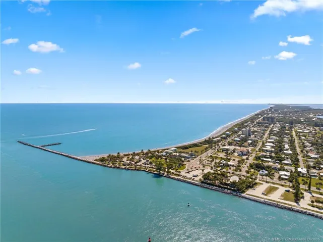 Sweeping aerial view captures the inlet, Atlantic coastline, and miles of Hutchinson Island shoreline.