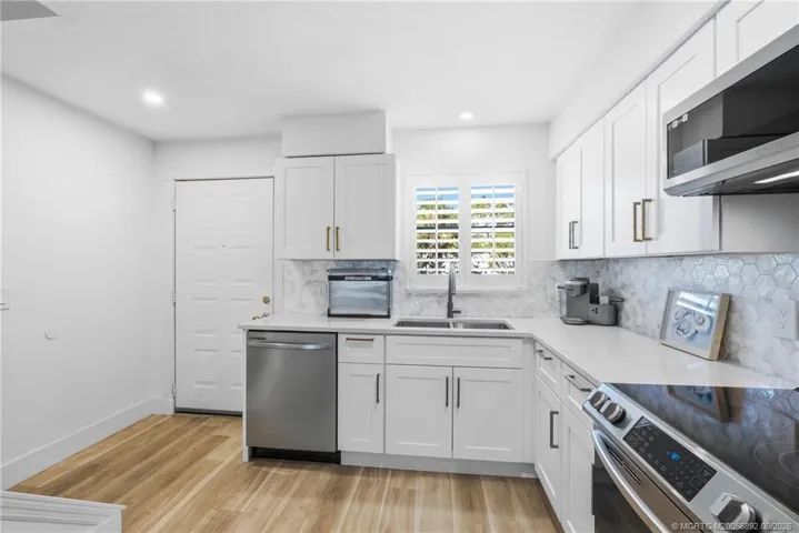 Another view of the updated kitchen highlights its efficient layout, generous storage, and stainless steel appliance package.